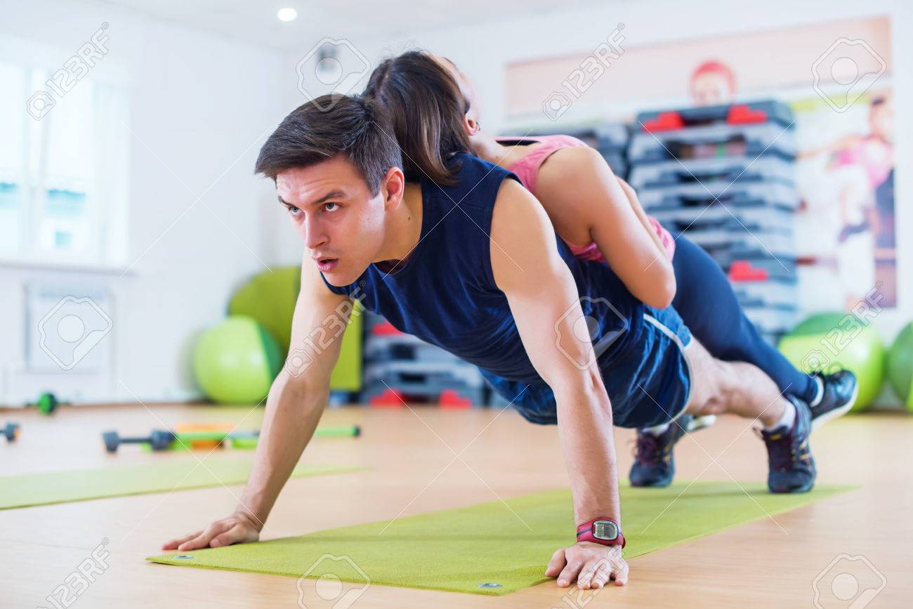 67951113-fit-man-doing-push-ups-with-woman-on-back-in-gym-using-own-weight-sport-training-arms-teamwork.jpg